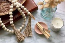 Load image into Gallery viewer, Natural Mango Wood Contentment Bead with Jute Tassels, staged with burn sticks.
