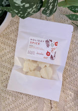 Load image into Gallery viewer, A white pouch of soy wax melts in the Holiday Spice scent laying flat on a woven mat.
