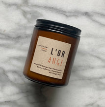 Load image into Gallery viewer, The L&#39;Orange candle scent from the Kitchen Collection, shown in 8 oz sized amber-colored glass jar.

