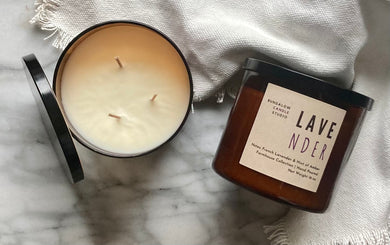 The Lavender candle scent from the Kitchen Collection, shown in large 16 oz sized amber-colored glass jar with 3 wicks.