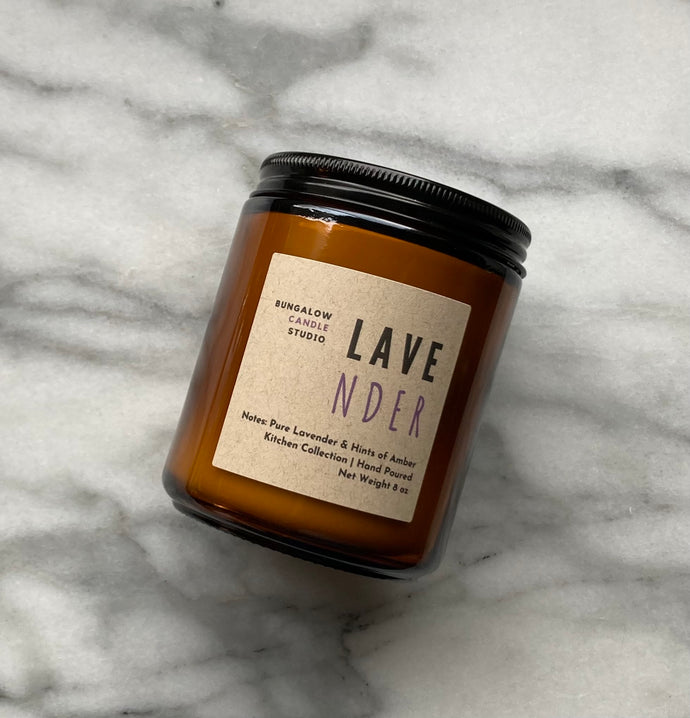 The Lavender candle scent from the Kitchen Collection, shown in 8 oz sized amber-colored glass jar.