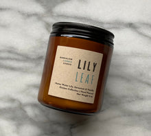 Load image into Gallery viewer, The Lily Leaf candle scent from the Kitchen Collection, shown in 8 oz sized amber-colored glass jar.
