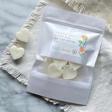 Soy Wax Melts in the shape of hearts and in a white sealed package with a window.