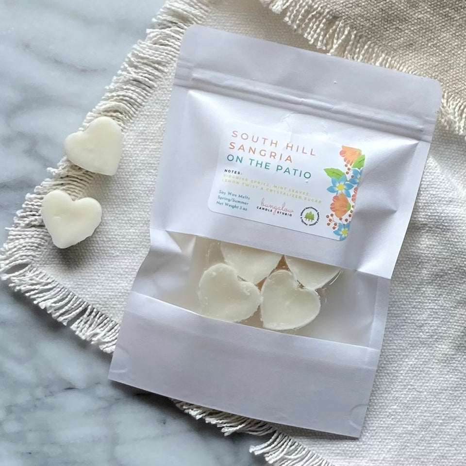 Soy Wax Melts in the shape of hearts and in a white sealed package with a window.