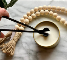 Load image into Gallery viewer, Wick trimmer being used to cut wick in a candle.
